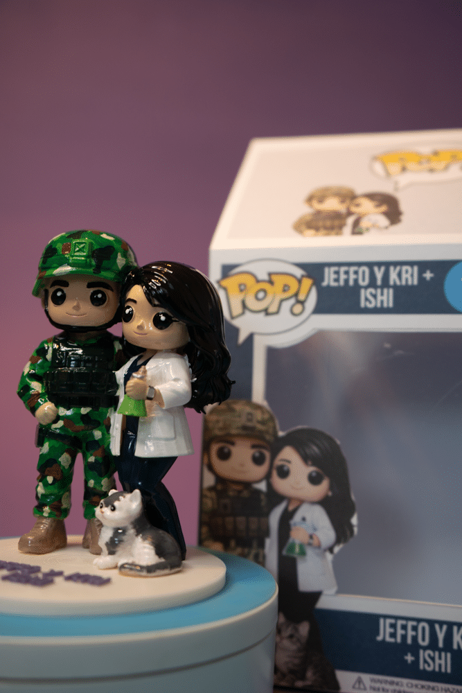 Figura 3D de una pareja junto a su gato, con caja Pop personalizada